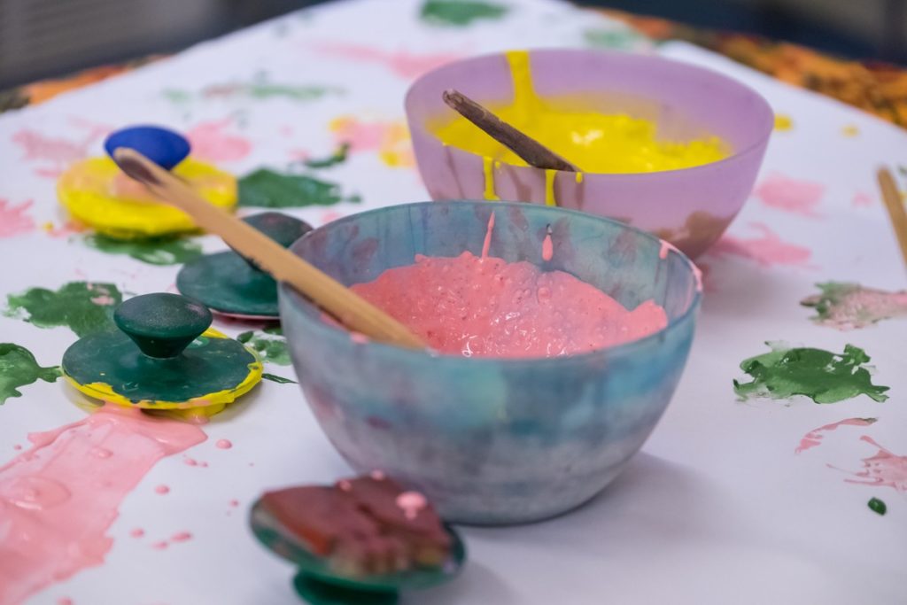two bowls of paint with paint brushes in them