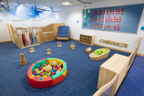 image of the baby room at little faces nursery, showing cot area and ball pit
