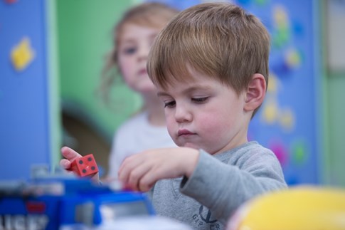 a child playing with a dice at little faces nursery in Waterlooville